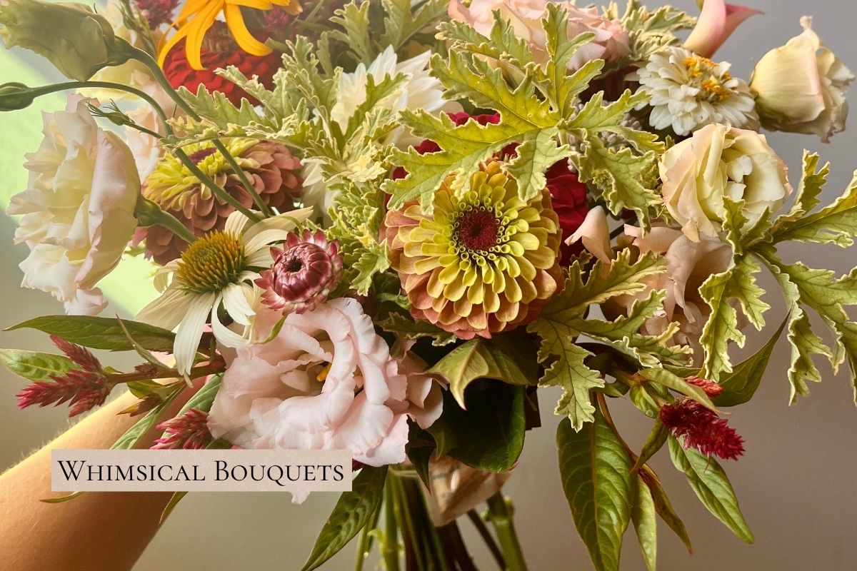 Close-up of a bouquet with zinnias and lisianthus in blush and red tones